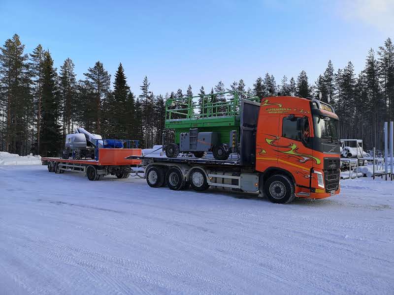 Kuorma-auto ja perävaunu kuljettavat henkilönostimia talvella